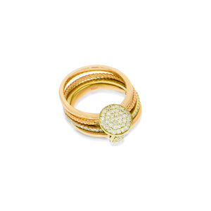 A collection of ring 4 gold rings connected, one in a wavy structure, one set with diamonds, connected by a clasp set with diamonds.